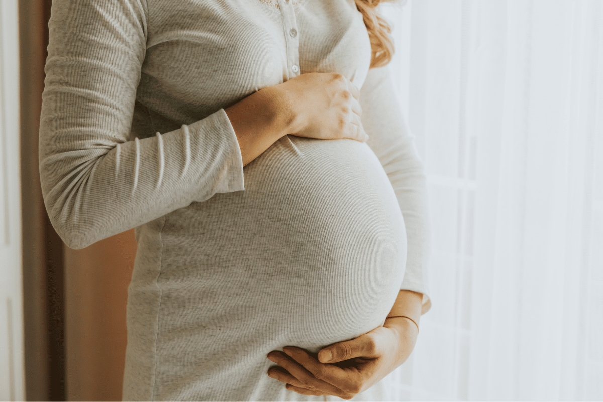Women holding her pregnancy bump with morning sickness